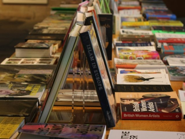 A row of books sitting on top of a wooden table