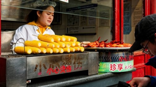 A woman standing in front of a food stand