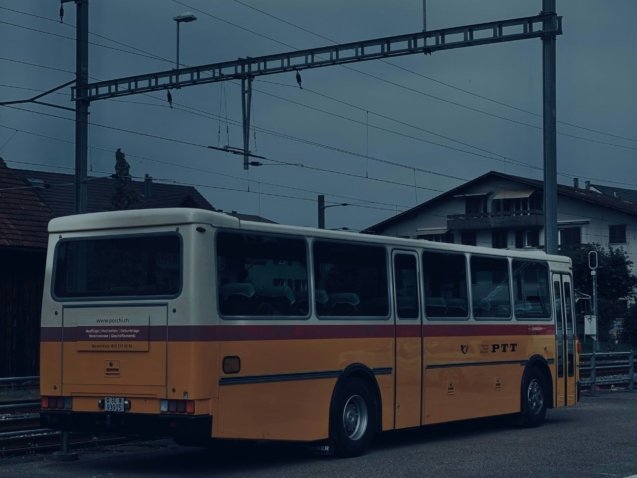A yellow and white bus parked in a parking lot