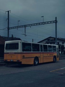 A yellow and white bus parked in a parking lot