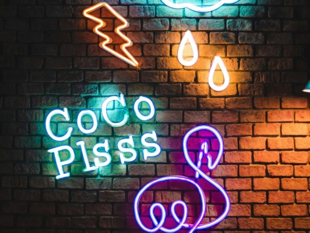 Coco Plsss neon signage hanging on brick wall