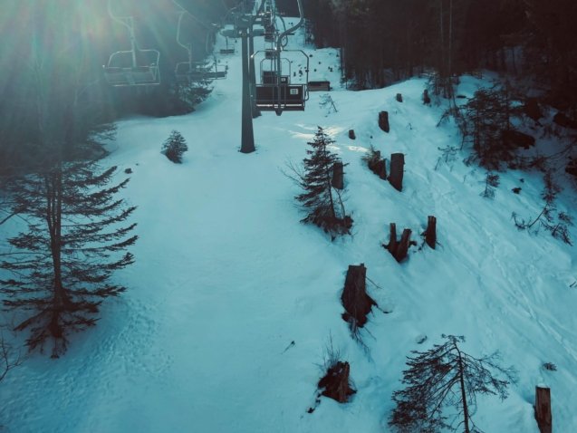 a ski lift going up a snowy hill