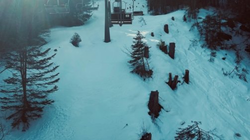 a ski lift going up a snowy hill