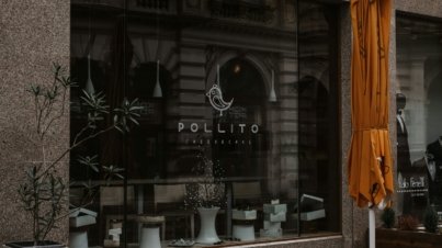 a store front with a yellow umbrella outside of it