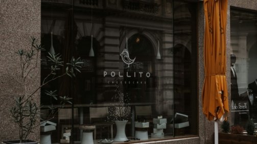 a store front with a yellow umbrella outside of it