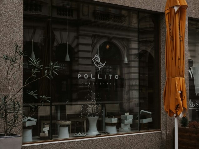 a store front with a yellow umbrella outside of it