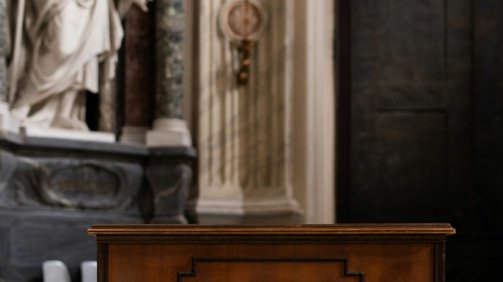 a wooden box sitting in front of a statue