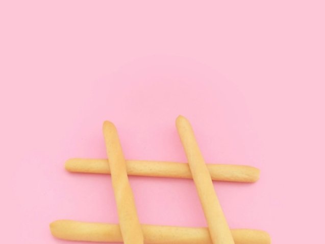 four brown wooden sticks on pink surface