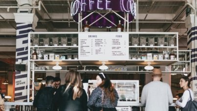 group of people standing in front of food stall counter