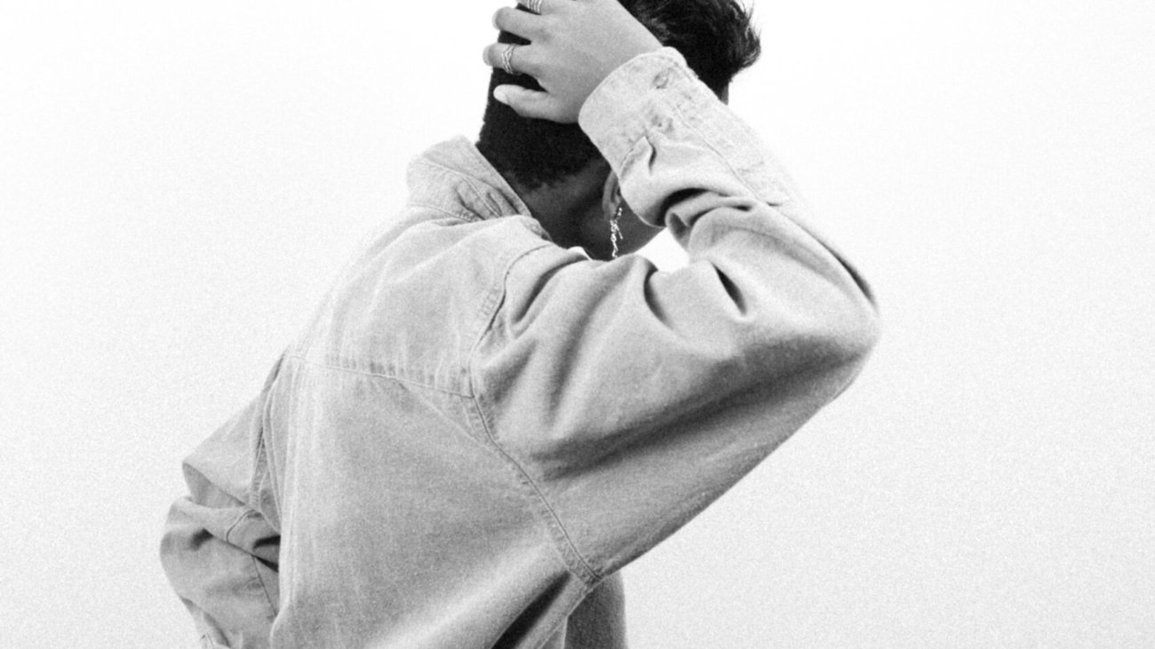 man in gray dress shirt covering face with his hands