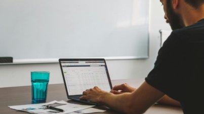 man sitting at the table while using laptop computer