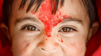 woman in red hijab with white powder on her face